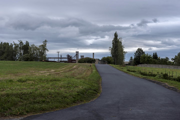 Fototapeta premium asphalt road leading around the fields to the factory