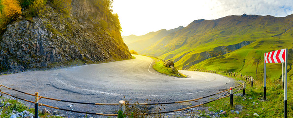 a sharp turn on a beautiful mountain road at sunset