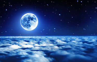 Heldere volle maan in een sterrenhemel boven dromerige wolken met zacht gloeiend licht