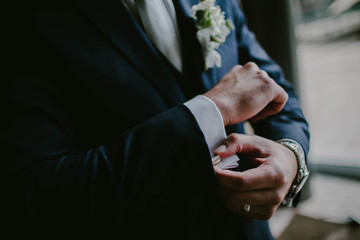 The groom wears cufflinks
