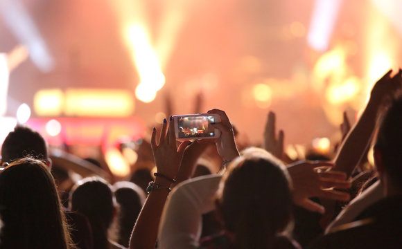 girl takes a picture during a concert