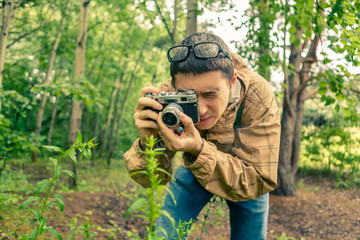 Guy biologist in glasses photographs plants
