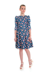 Woman in blue patterned dress. Slim legs in heels. Summer garment. Outfit from new collection.