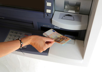 young woman while withdrawing banknotes  from an ATM