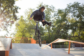 BMX rider training and do tricks in street plaza, bicyxle stunt rider in cocncrete skatepark 