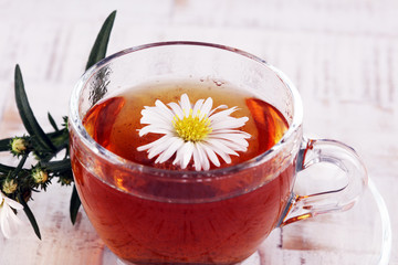 cup of tea with chamomile flowers on rustic background