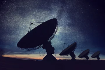 Foto op Canvas Silhouetten van satellietschotels of radioantennes tegen de nachtelijke hemel. Ruimte observatorium. © vchalup