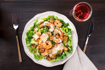Overhead photo of shrimp Caesar salad with rose wine