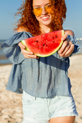 Young female  on the sea shore enjoying  with watermelon.