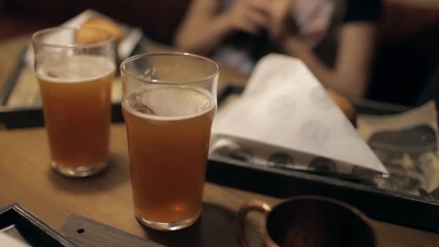 Beer With Burgers on a Table in a Dark Cafe