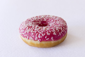 Brightly pink donut on a white background