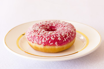 Brightly pink donut on a white background