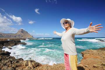 lebensfrohe ältere Frau am Strand