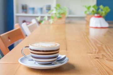 Cappuccino coffee in cup on wooden table