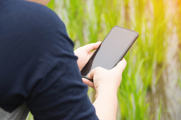 people holding smartphone with nature background.