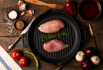 Raw Chicken Fillets in cooking pan and Vegetables with Spices