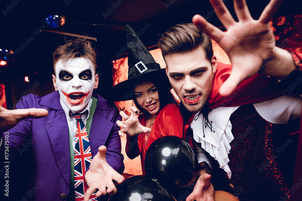 Wall mural halloween party. adult people in terrible costumes for a party for halloween posing with scary faces