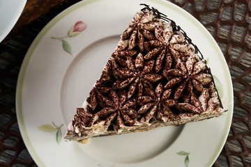 Slice of chocolate cake with biscuit on plate