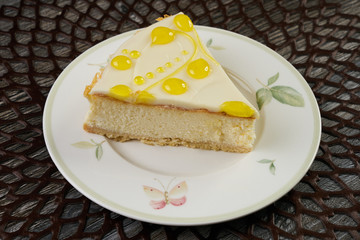 Slice of citrus lemon cheesecake on white plate