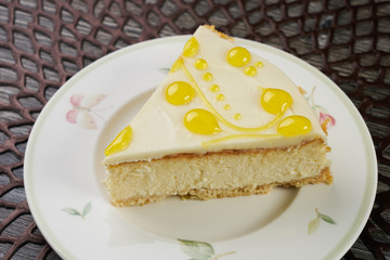 Slice of citrus lemon cheesecake on white plate