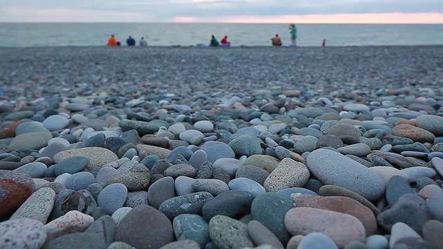 pebble beach and the sea on the background of the mountain and rest people