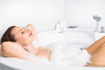 Obraz na płótnie Canvas Young woman enjoying bathing in bathtub