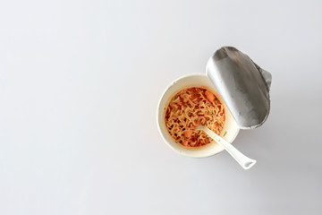 closeup mama or noodle in cup and tomyam soup on white table with sofe-focus and over light in the background