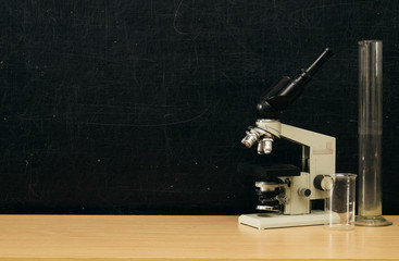 Teacher or student desk table. Education background. Education concept. Microscope, flasks and beakers on the table.