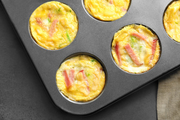 Baking mold with tasty egg muffins on table