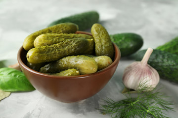Bowl with pickled cucumbers on table