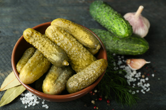 Bowl with pickled cucumbers on wooden table