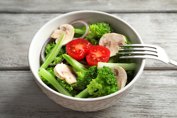 Bowl with broccoli salad on table