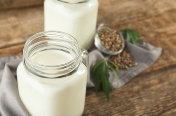 Jar with hemp milk on wooden table