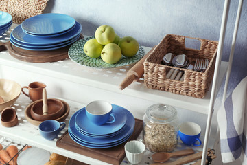 Colorful tableware and fruits on storage stand indoors