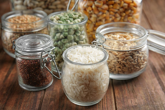 Glass jars with different grains on kitchen table