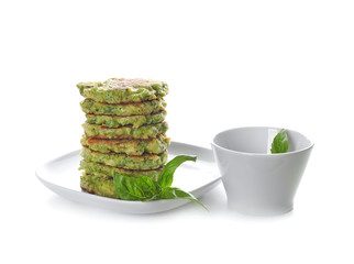 Plate with delicious broccoli pancakes on white background