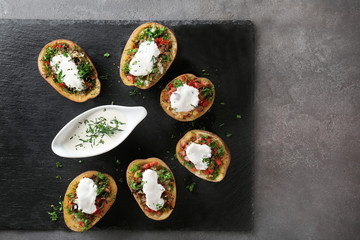 Stuffed potatoes served with sauce on slate plate