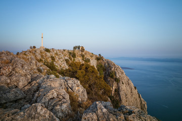 Fototapeta na wymiar Cross and Small Chapel On the Top of Sveti Nikola - the Highest Mountain on Hvar Island, Dalmatia, Croatia
