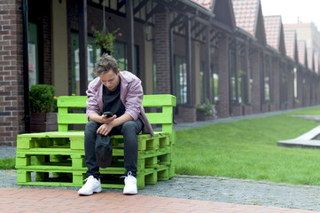 young man with a phone sitting on a bench