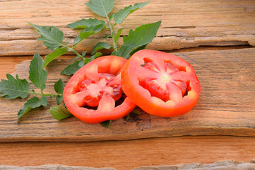 Two tomatoes on wooden floor