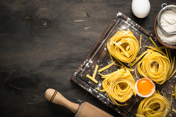 Prepartion homemade pasta tagliatelle at wooden table. Top view copy space.