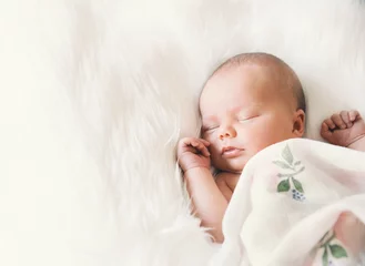 Fototapeten Sleeping newborn baby in a wrap on white blanket. © nataliaderiabina