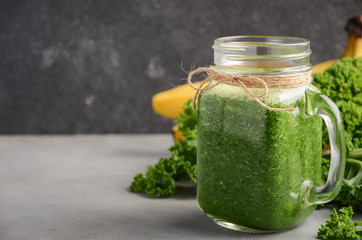 Fresh green smoothie with kale and banana, selective focus, copy space.