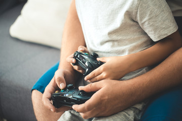 Father with son with joystick controllers in hands © Kirill Grekov
