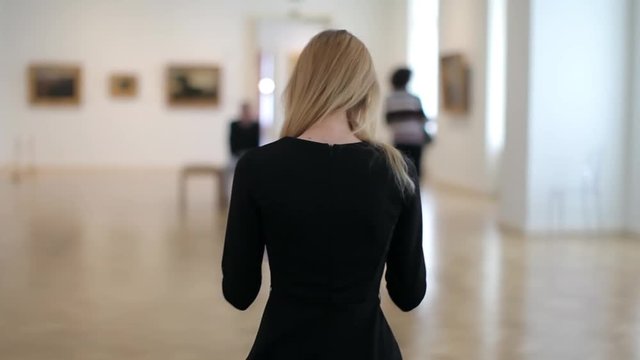 Young Woman Sits in a Picture Gallery in Museums