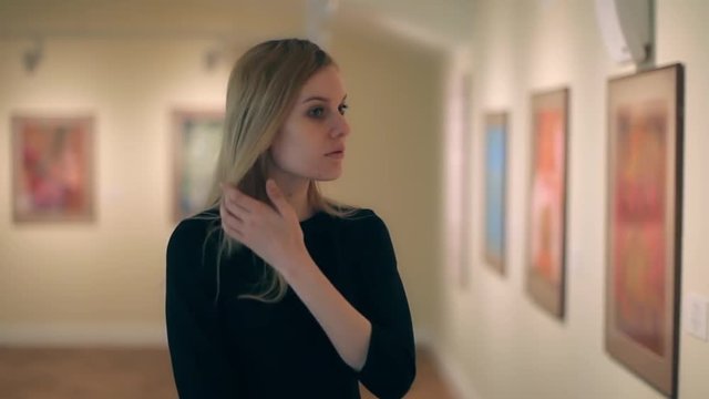 Young Woman Looking at a Picture in a Museum