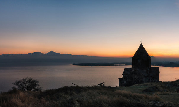 Panoramic view of the temple complex on the Sevan Lake at sunset, Armenia. Silhouettes of St. Jakob Church and Sevanavank. Armenian landmarks