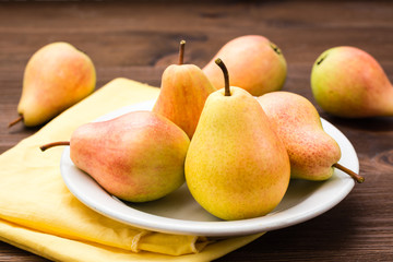 Ripe pears on a plate on a wooden table