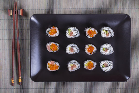 Sushi roll with salmon, cucumber, avocado, red caviar. Sushi menu. Japanese food. Close up, top view