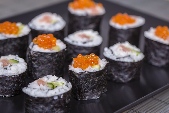 Sushi roll with salmon, cucumber, avocado, red caviar. Sushi menu. Japanese food. Close up